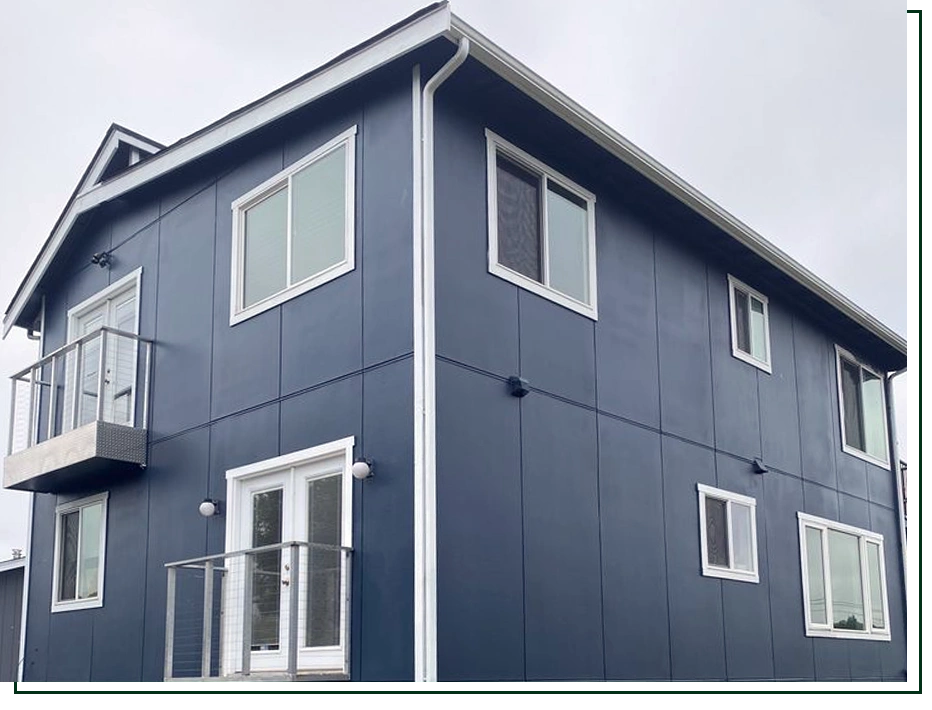 A two-story house with dark blue vertical panel siding